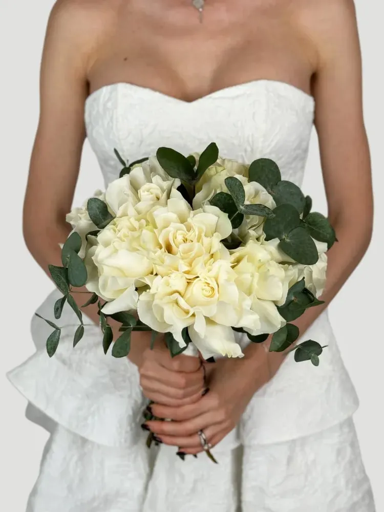 Bride holding a white rose and eucalyptus bouquet