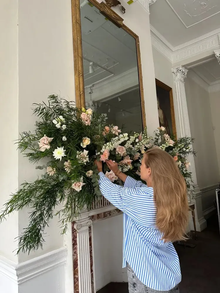 Florist fitting a floral garland on site