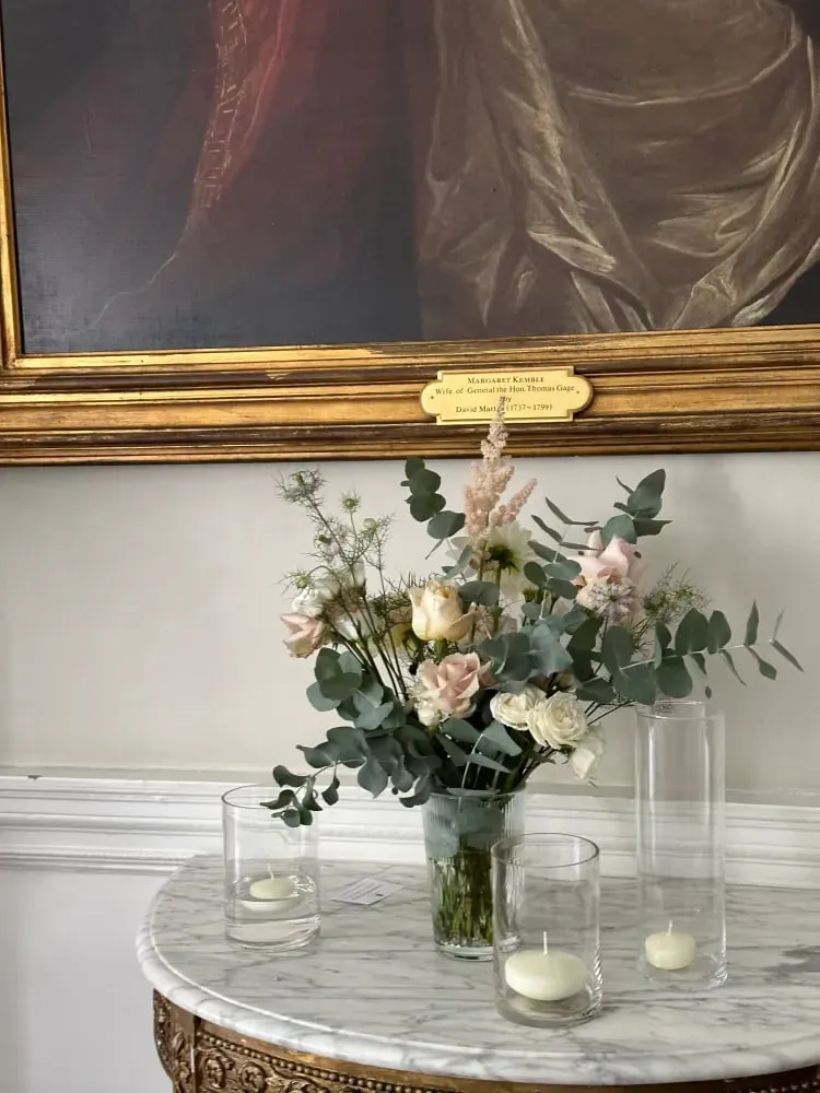 Glass vase arrangement with tea lights on a marble table